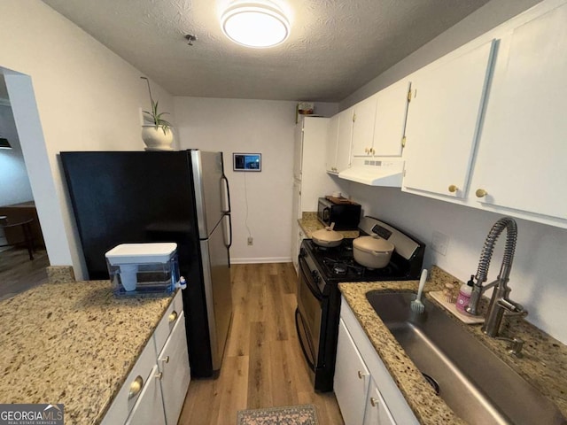 kitchen featuring white cabinetry, stainless steel range, sink, a textured ceiling, and exhaust hood