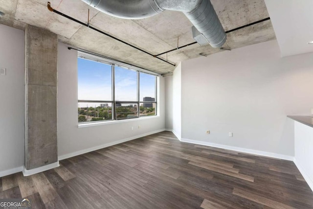 unfurnished room with dark wood-type flooring