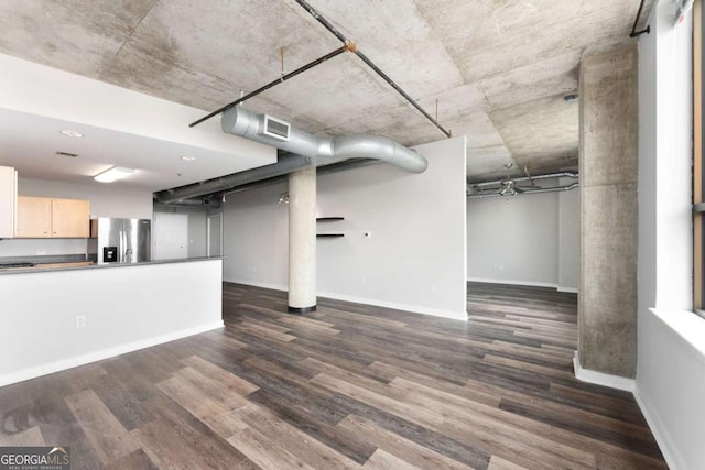 basement with stainless steel fridge with ice dispenser and dark hardwood / wood-style flooring