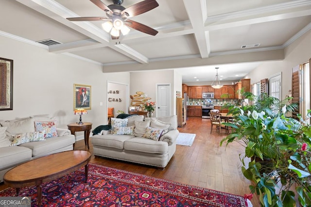 living room with coffered ceiling, crown molding, ceiling fan, beamed ceiling, and dark hardwood / wood-style flooring