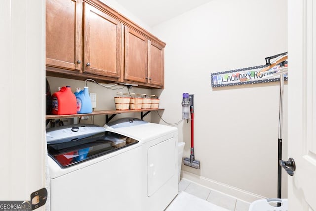 washroom with cabinets, washing machine and dryer, and light tile patterned floors