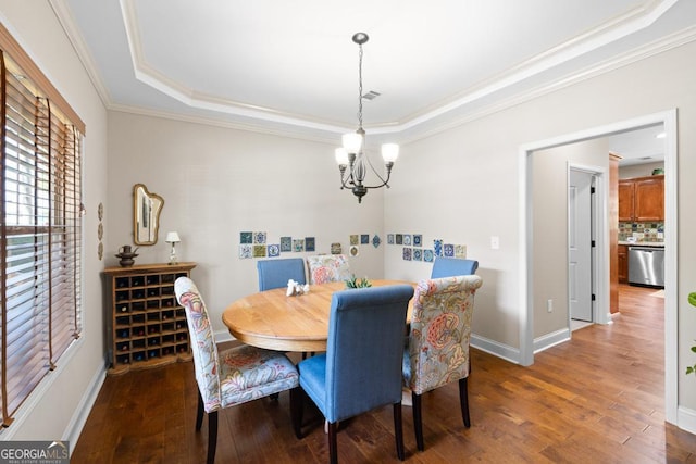 dining room with dark hardwood / wood-style flooring, a raised ceiling, ornamental molding, and a notable chandelier