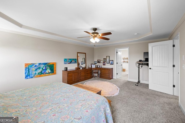 bedroom featuring ensuite bathroom, crown molding, ceiling fan, a tray ceiling, and light colored carpet