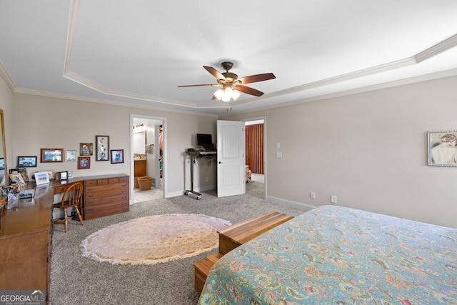 bedroom featuring light carpet, ornamental molding, a raised ceiling, ceiling fan, and connected bathroom