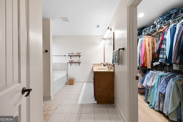 bathroom featuring a tub, tile patterned flooring, and vanity