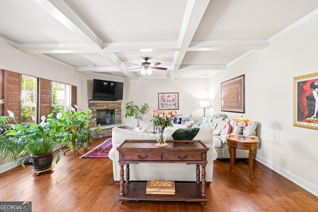 living room featuring dark hardwood / wood-style flooring, a fireplace, coffered ceiling, ceiling fan, and beamed ceiling