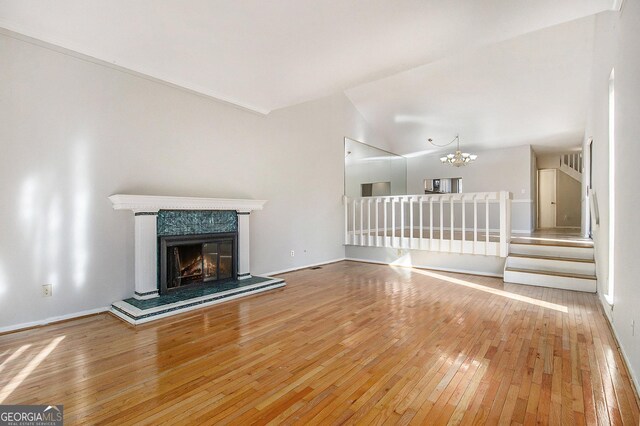 unfurnished living room featuring ceiling fan, a fireplace, ornamental molding, and hardwood / wood-style flooring