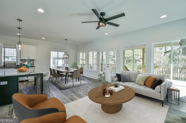 living room with ceiling fan and light hardwood / wood-style flooring