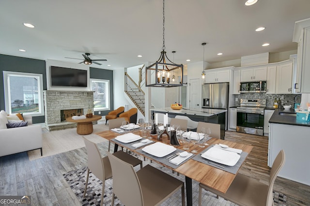 200 Greenpeace Way, Martin, GA 30557 - dining room with recessed lighting, wood finished floors, a fireplace, stairs, and ceiling fan with notable chandelier
