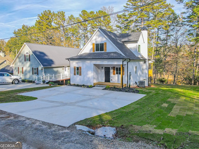 view of front of home with cooling unit, a front lawn, and covered porch