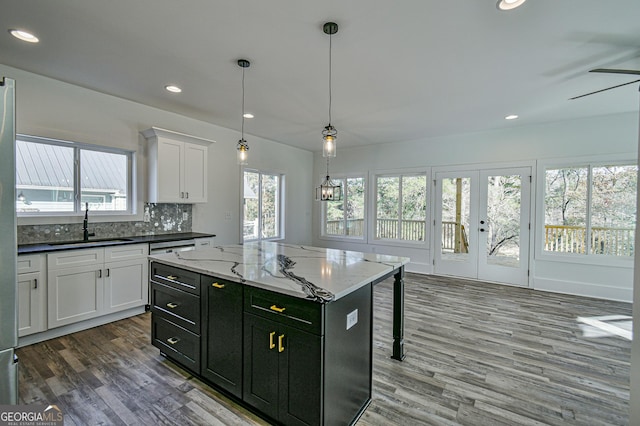 200 Greenpeace Way, Martin, GA 30557 - kitchen featuring white cabinets, wood finished floors, dark cabinetry, a sink, and hanging light fixtures