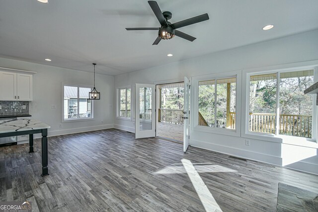 unfurnished living room featuring ceiling fan, a fireplace, and wood-type flooring