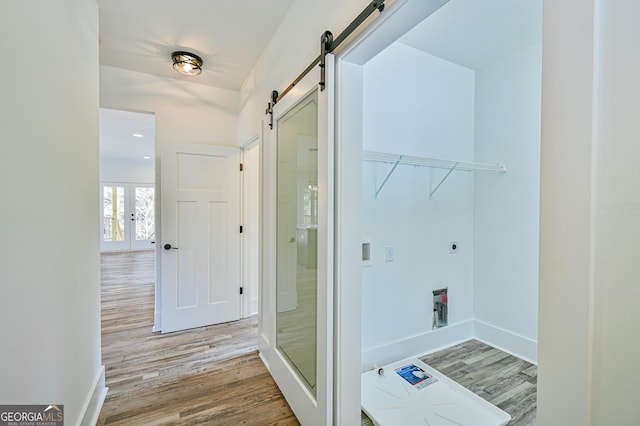 laundry area featuring hardwood / wood-style floors, electric dryer hookup, a barn door, and french doors