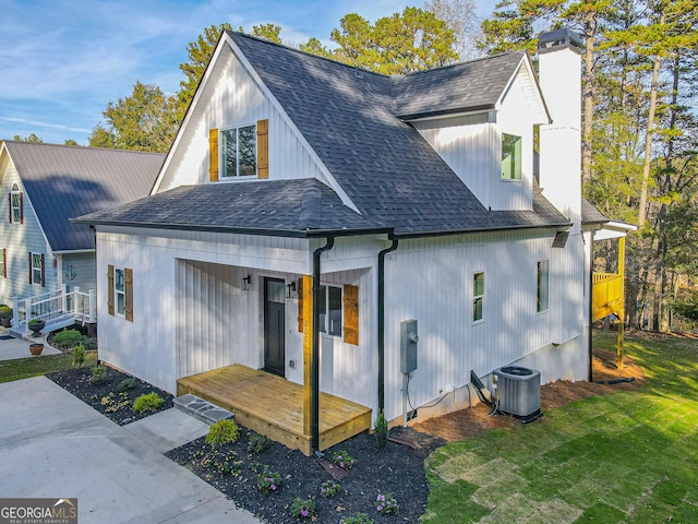 back of house with a yard and central AC