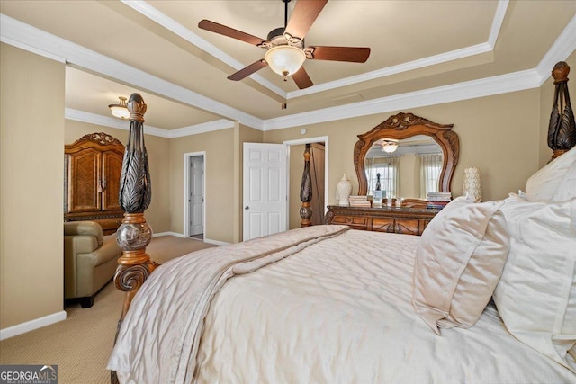 carpeted bedroom featuring ceiling fan, crown molding, and a tray ceiling