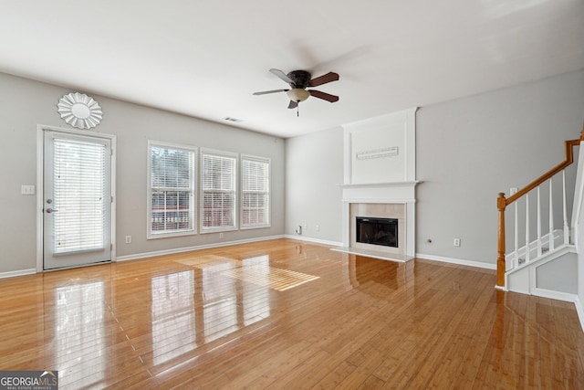 unfurnished living room featuring ceiling fan and light hardwood / wood-style flooring