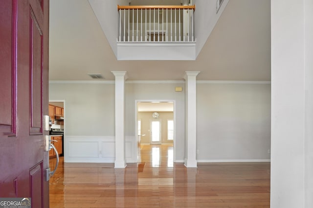 entryway with ornate columns and crown molding