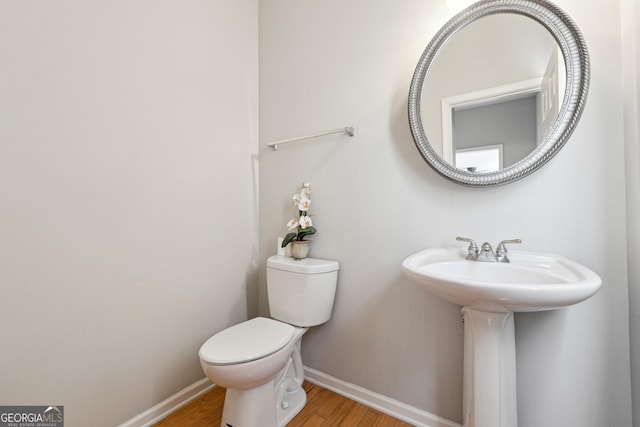 bathroom featuring hardwood / wood-style flooring, toilet, and sink