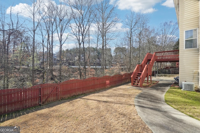 view of yard featuring a deck and central air condition unit