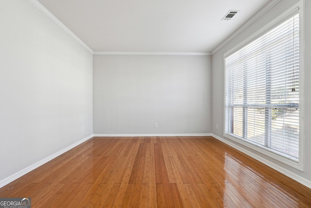 unfurnished room featuring crown molding, plenty of natural light, and light hardwood / wood-style flooring