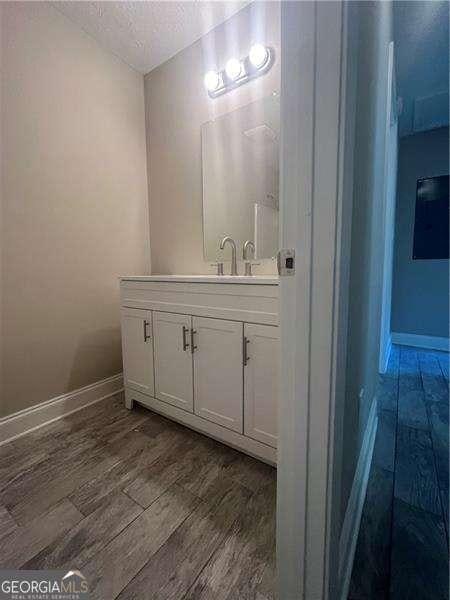 bathroom with vanity, a textured ceiling, and hardwood / wood-style flooring