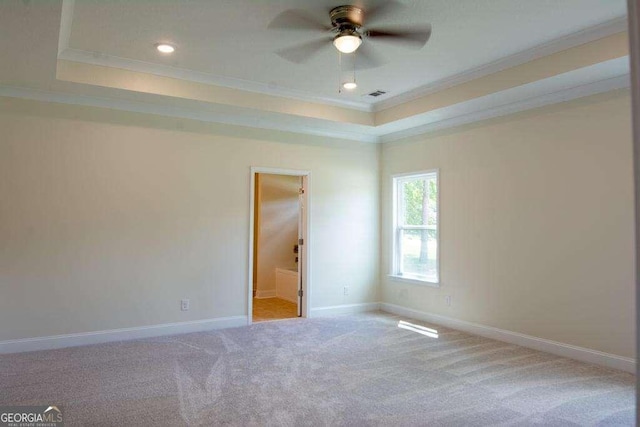 carpeted empty room featuring a tray ceiling, ceiling fan, and ornamental molding