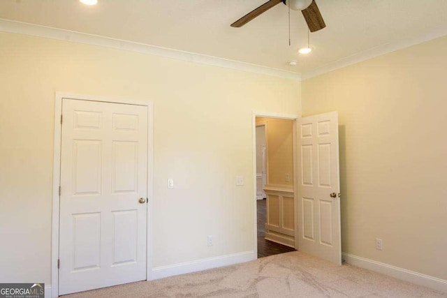 unfurnished bedroom with ceiling fan, crown molding, and carpet