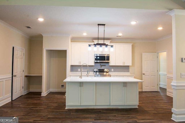 kitchen featuring a center island with sink, decorative light fixtures, crown molding, and stainless steel appliances