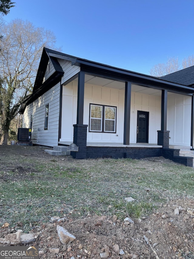 view of side of property with a porch and cooling unit