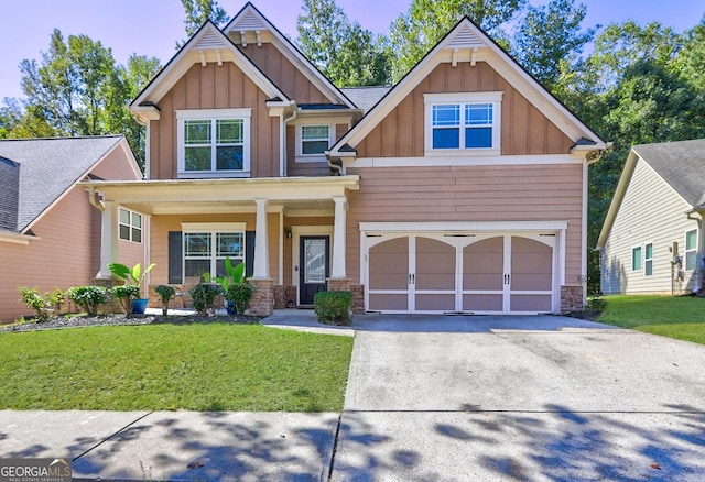 craftsman inspired home featuring driveway, stone siding, a porch, board and batten siding, and a front yard