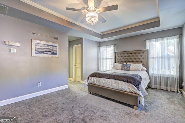 bedroom featuring ornamental molding, a tray ceiling, and visible vents