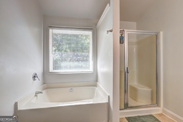 full bathroom featuring a stall shower, tile patterned flooring, and a garden tub