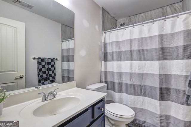 bathroom with toilet, visible vents, and vanity