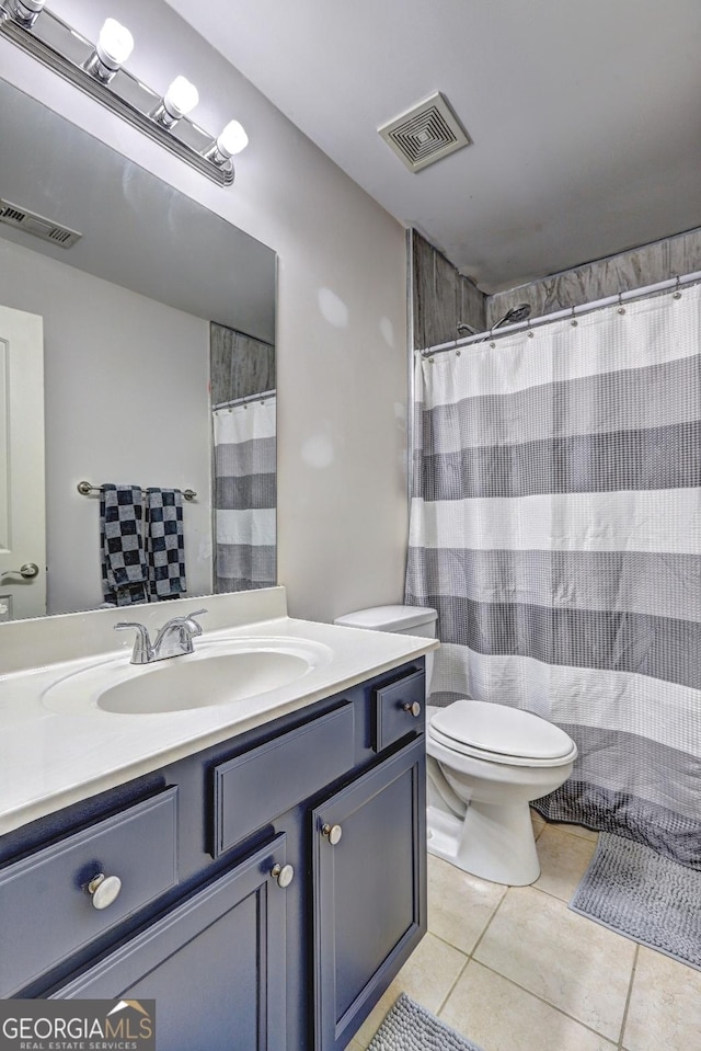 bathroom with toilet, vanity, visible vents, and tile patterned floors