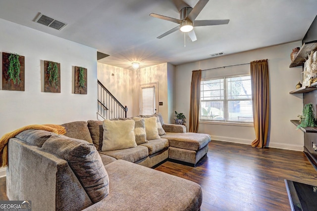 living area with visible vents, stairway, dark wood-type flooring, ceiling fan, and baseboards