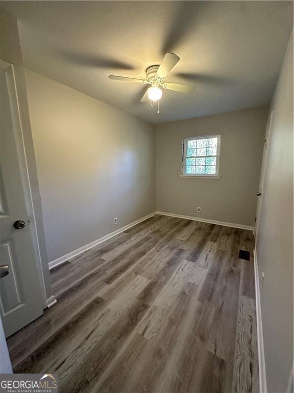 spare room featuring wood-type flooring and ceiling fan