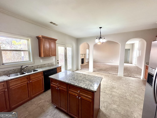 kitchen with black dishwasher, light stone countertops, sink, pendant lighting, and stainless steel fridge