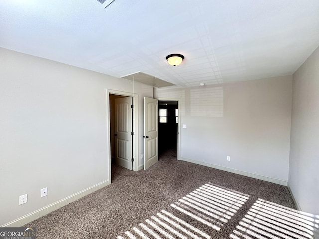 empty room with dark colored carpet