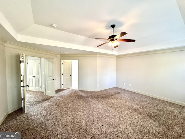 carpeted empty room featuring crown molding, ceiling fan, and a tray ceiling