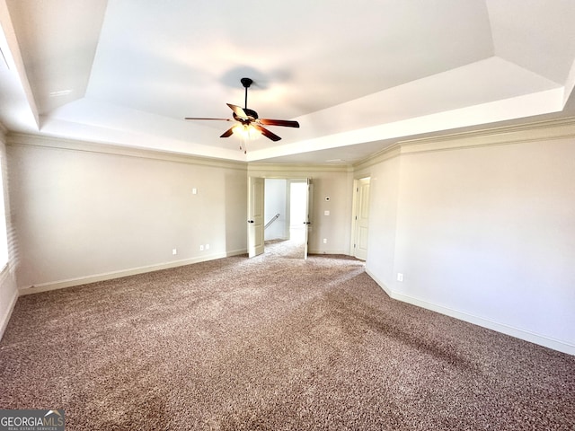 carpeted spare room with ceiling fan, a raised ceiling, and crown molding