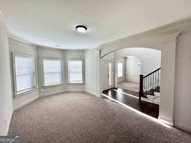 carpeted foyer entrance featuring ornamental molding