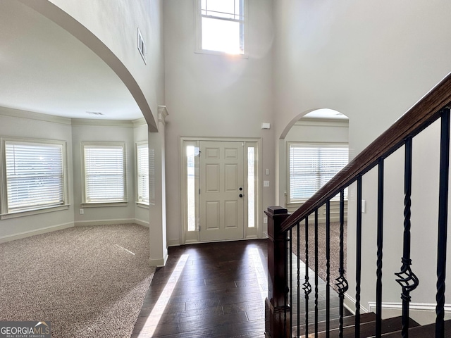 entryway featuring a high ceiling, dark hardwood / wood-style floors, and ornamental molding