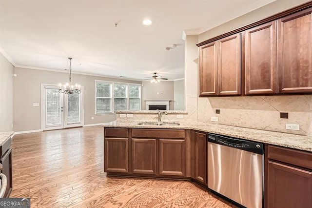 kitchen featuring light stone countertops, stainless steel appliances, sink, light hardwood / wood-style flooring, and a notable chandelier