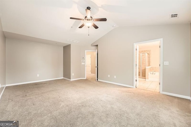 spare room featuring ceiling fan, light carpet, and lofted ceiling