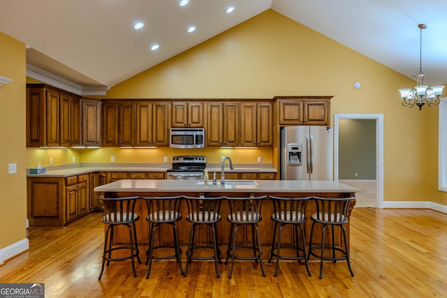 kitchen with appliances with stainless steel finishes, a center island with sink, a breakfast bar area, and sink