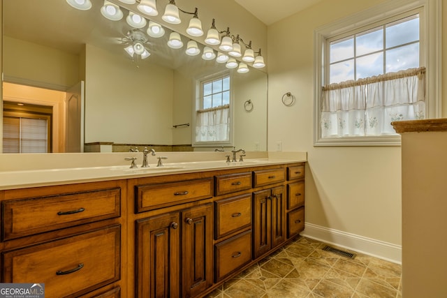 bathroom featuring vanity, ceiling fan, and a healthy amount of sunlight