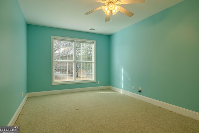 empty room with ceiling fan and light colored carpet