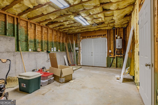 miscellaneous room featuring water heater and concrete flooring