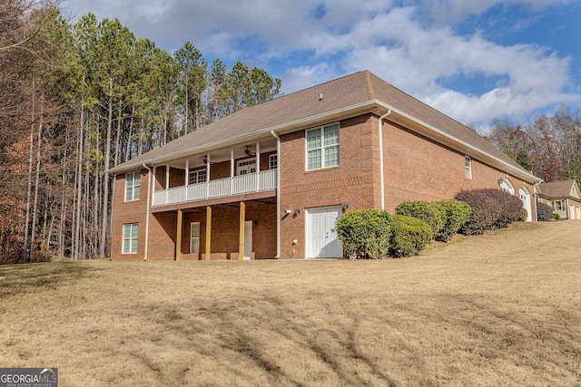 rear view of house with ceiling fan and a balcony