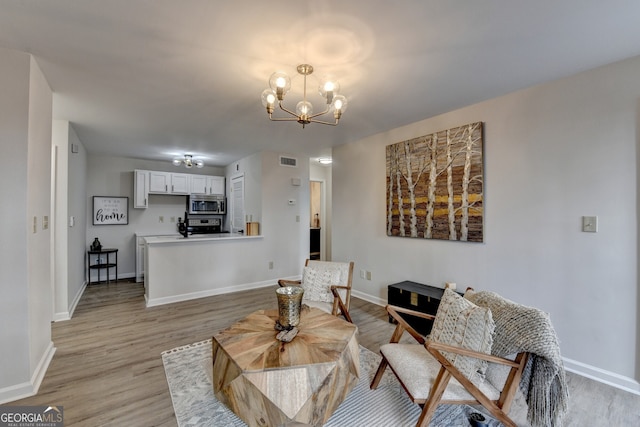 sitting room with light hardwood / wood-style flooring and a chandelier